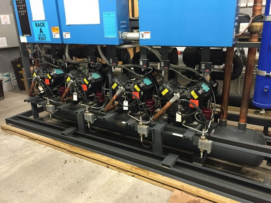 A row of compressors are sitting next to each other in a room.