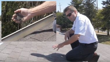 Man kneeling outdoors, gesturing toward cracked pavement near a rooftop edge with a small inset of a damaged handrail