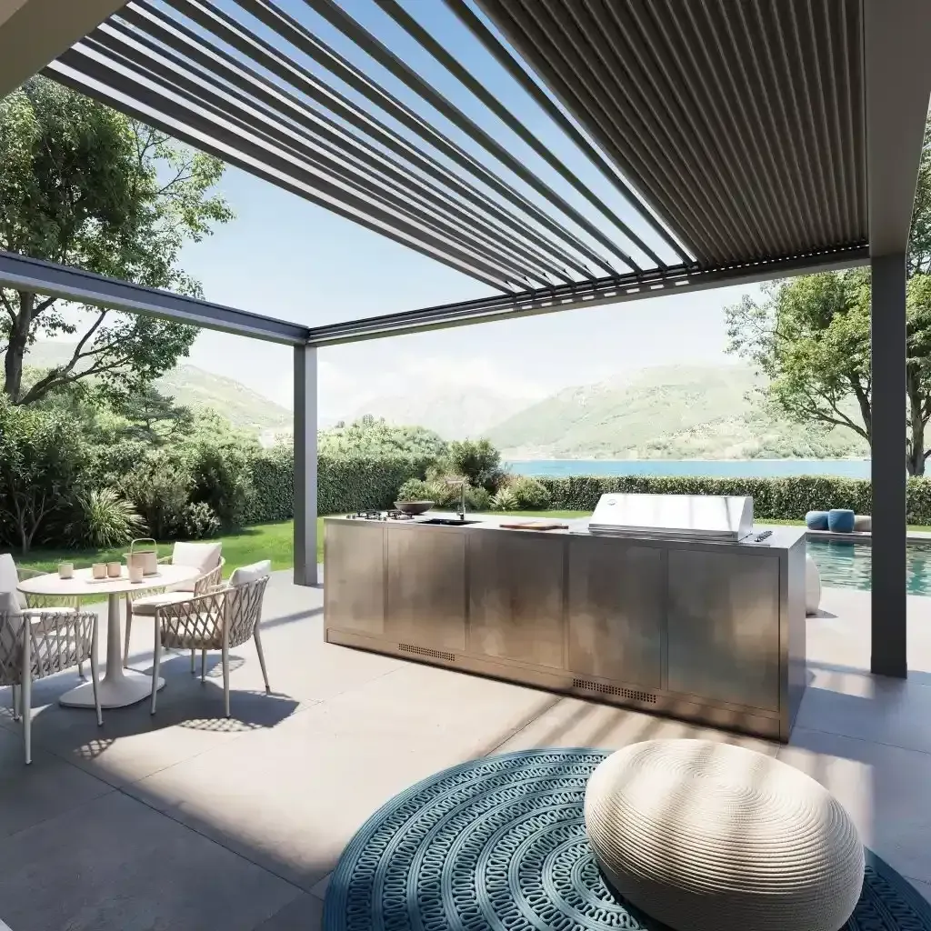 Patio moderno con pergola bioclimatica, cucina esterna, tavolo da pranzo e vista sulle montagne con affaccio sulla piscina.