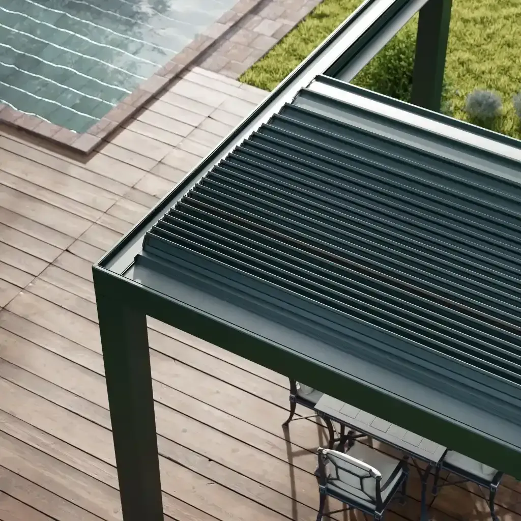 Pergola bioclimatica verde scuro, tetto a doghe e terrazza a bordo piscina sottostante.