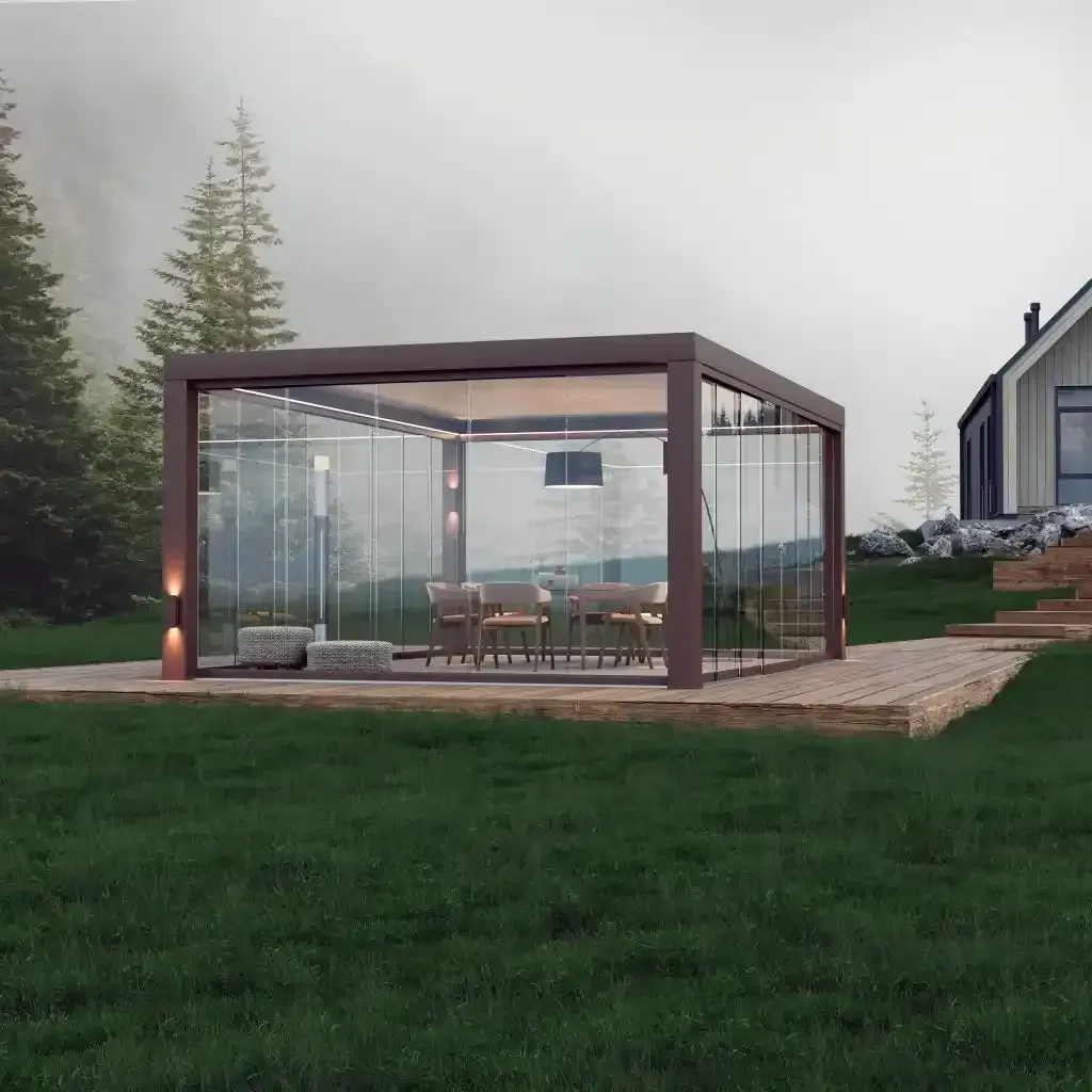 Pergola bioclimatica in vetro con posti a sedere su un prato al crepuscolo, con alberi e una casa sullo sfondo.