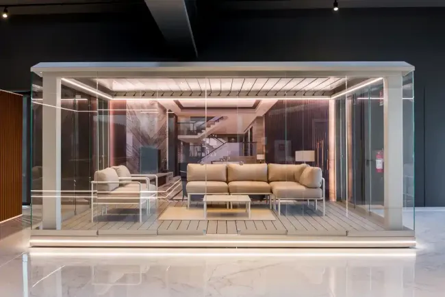 Moderno soggiorno in una vetrata panoramica, divani beige, arredamento minimalista e illuminazione calda.