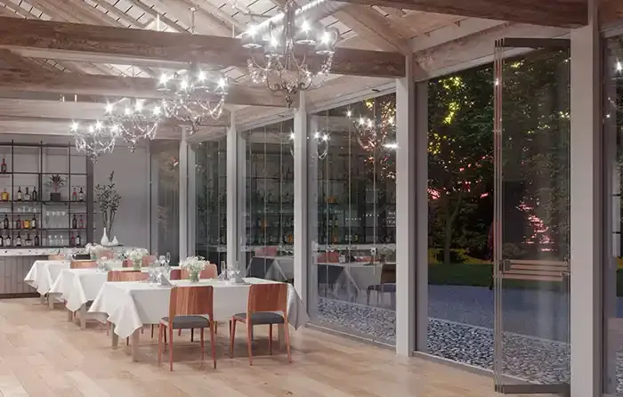Elegante sala da pranzo interna con tovaglie bianche, sedie in legno e ampia vetrata panoramica che si affaccia sul giardino.