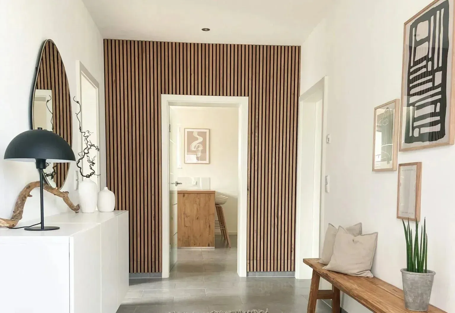 Corridoio moderno con parete con pannello fonoassorbente legno, decorazioni bianche, panca e vista sul bagno.