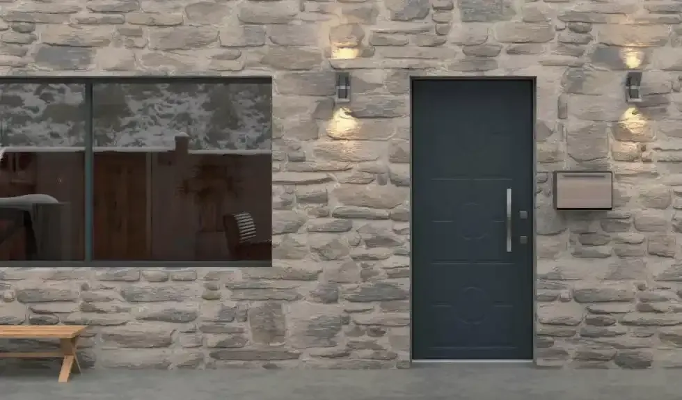 Facciata di un edificio in pietra con porta scura, finestra, applique e una panchina.