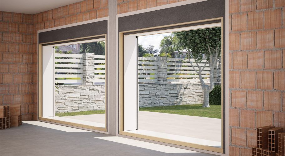 Interni moderni con due grandi porte scorrevoli in vetro che incorniciano un patio e un giardino esterni.