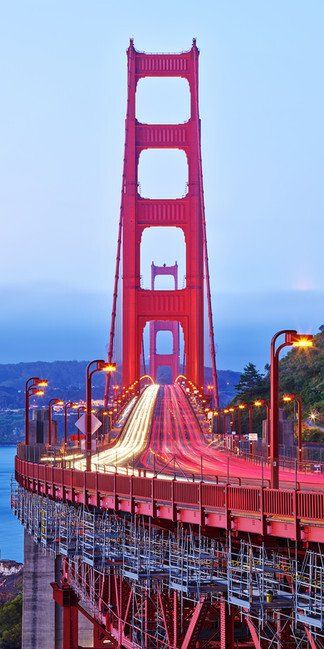 Golden Gate Bridge at dusk with light trails from traffic and a blue-purple sky