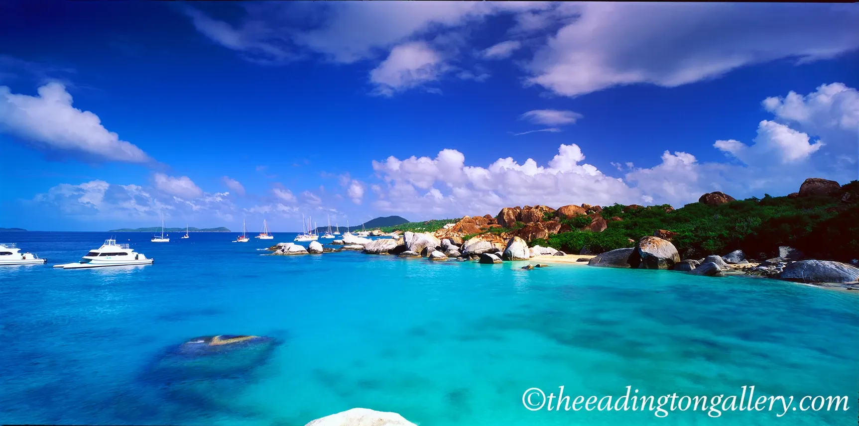 Tropical beach with turquoise water, white boats, and a sunny blue sky