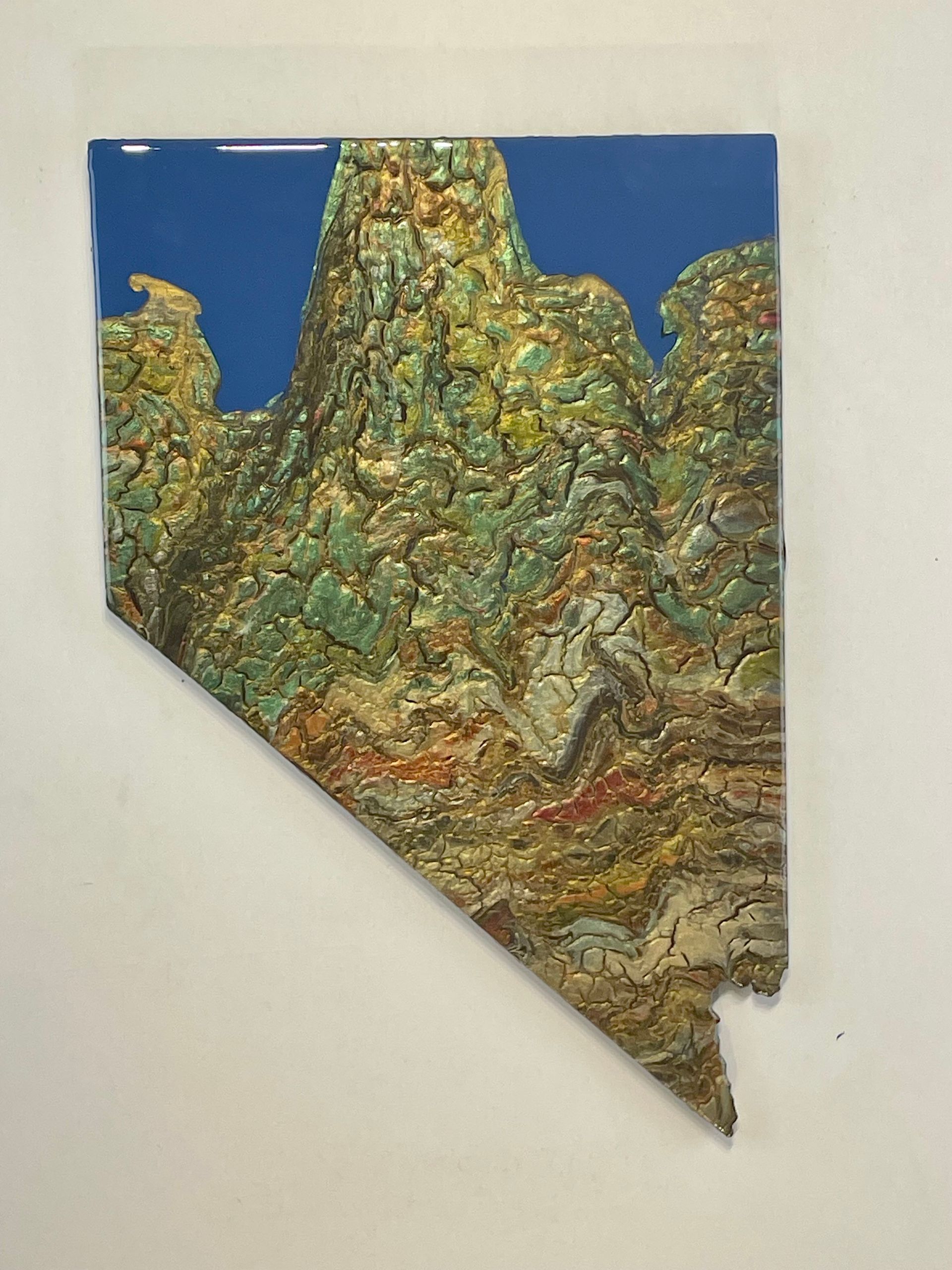 Abstract textured art in green and gold on a blue background, shaped like a jagged peninsula