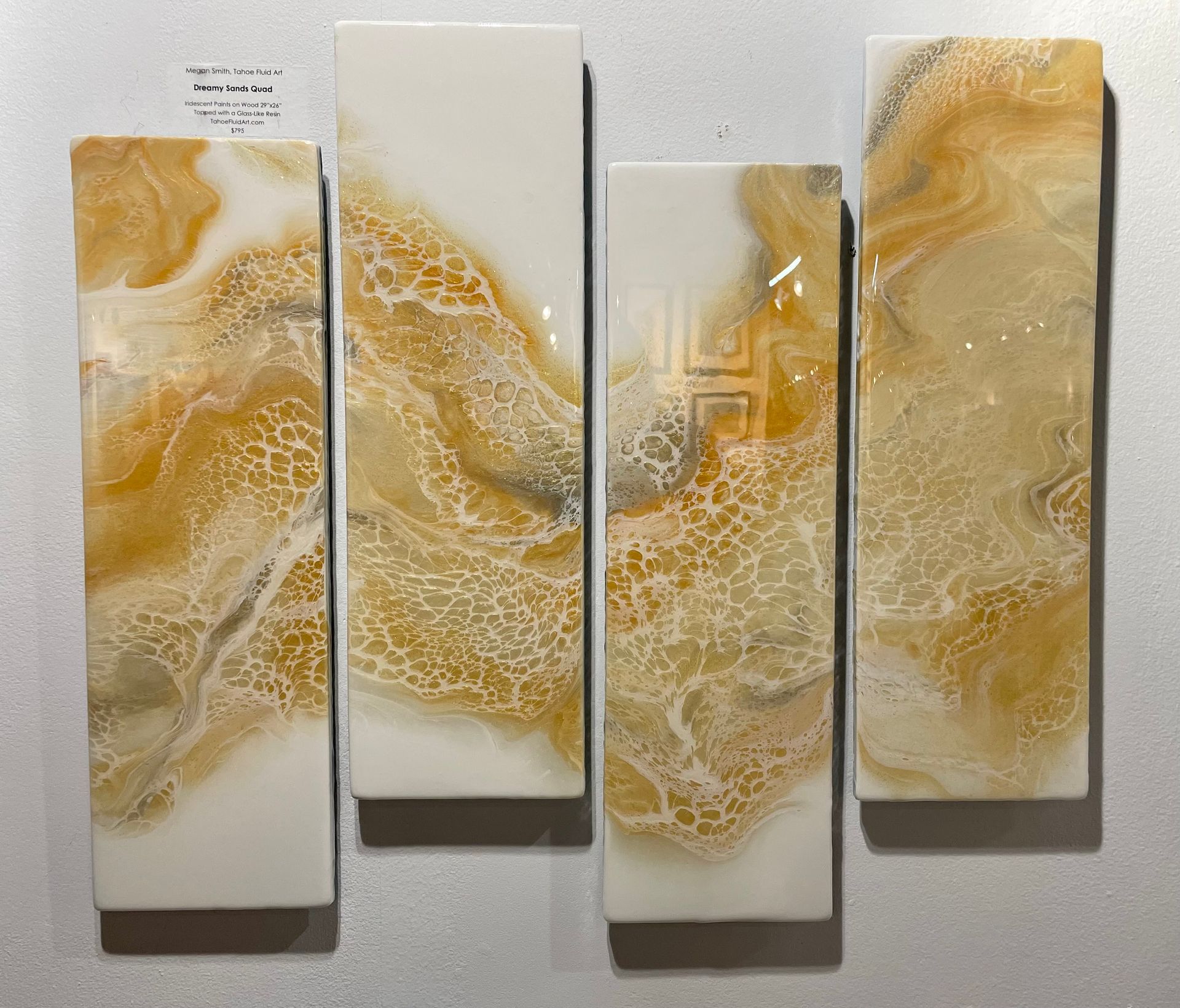 Four abstract cream-and-gold textured wall panels arranged in a row on a light background