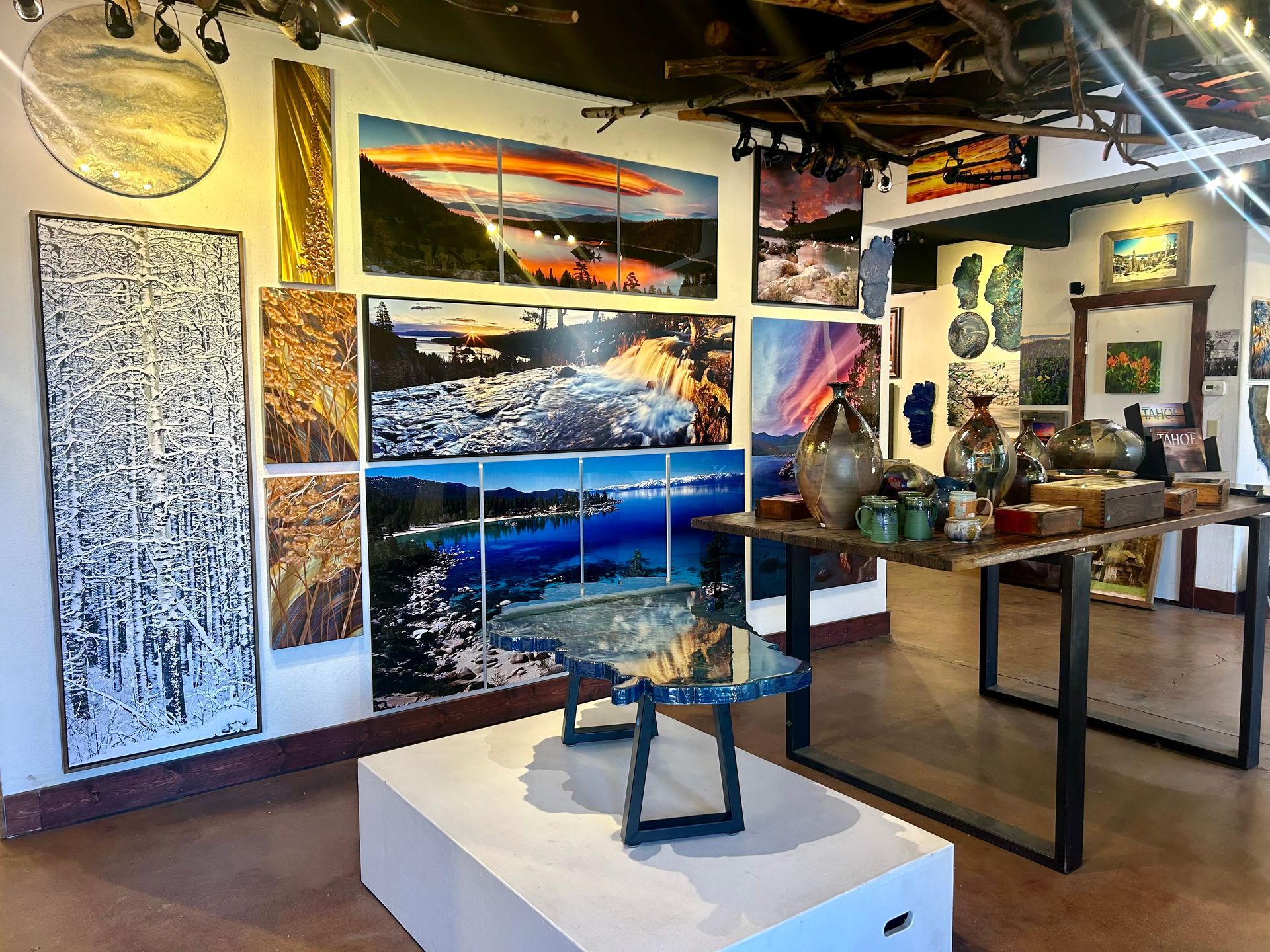 Art gallery interior with colorful landscape paintings and sculptures on display