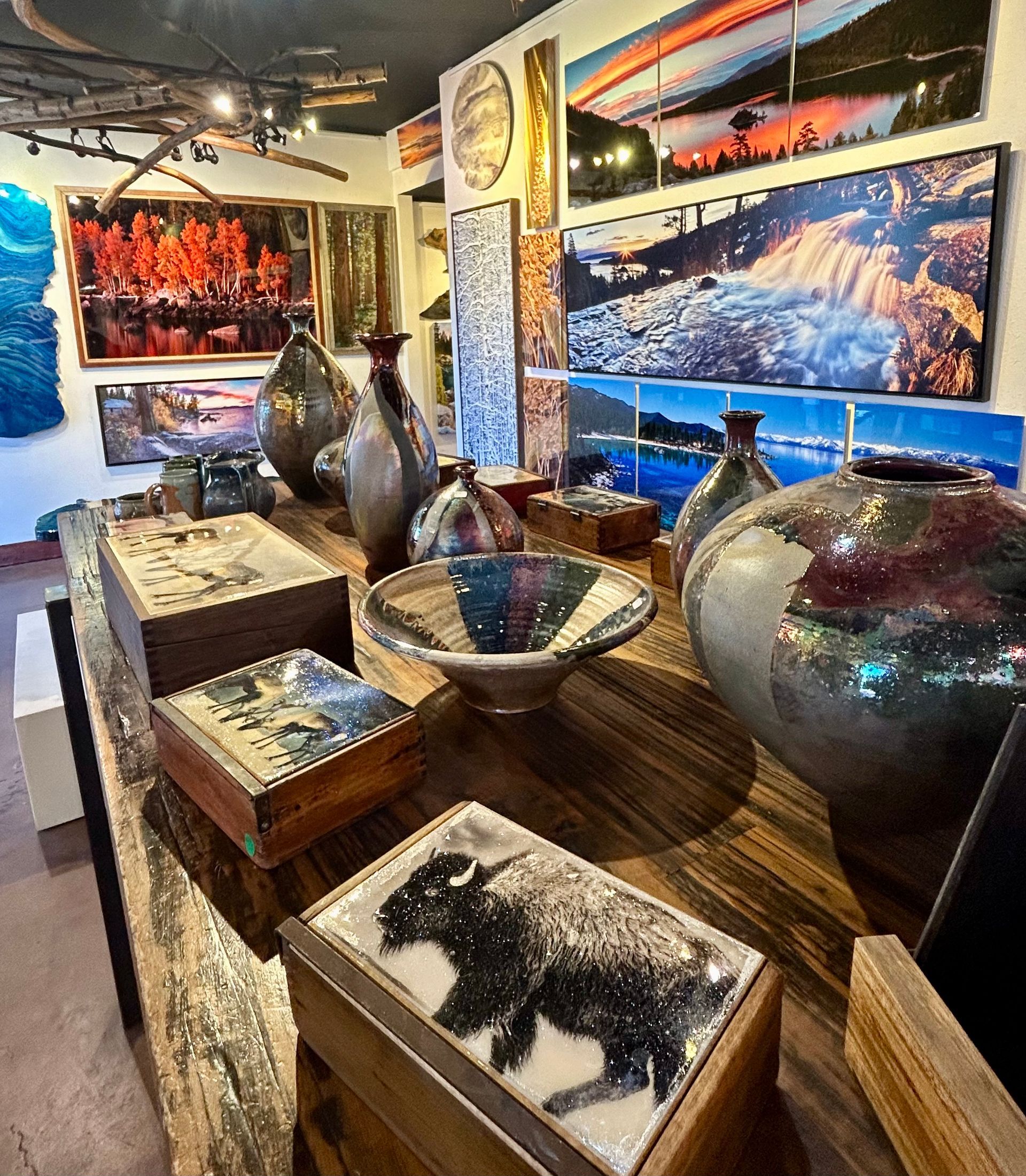 Gallery display of ceramic vases and tables with animal art in a colorful exhibition room
