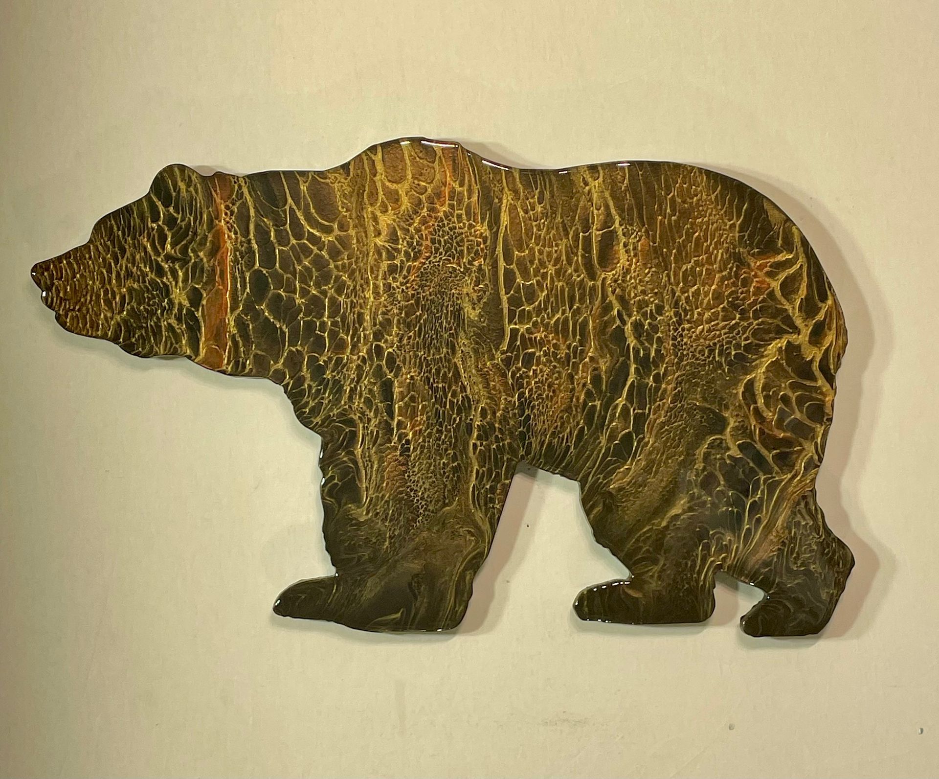 Bear silhouette wall art in dark brown with textured gold pattern on a light background