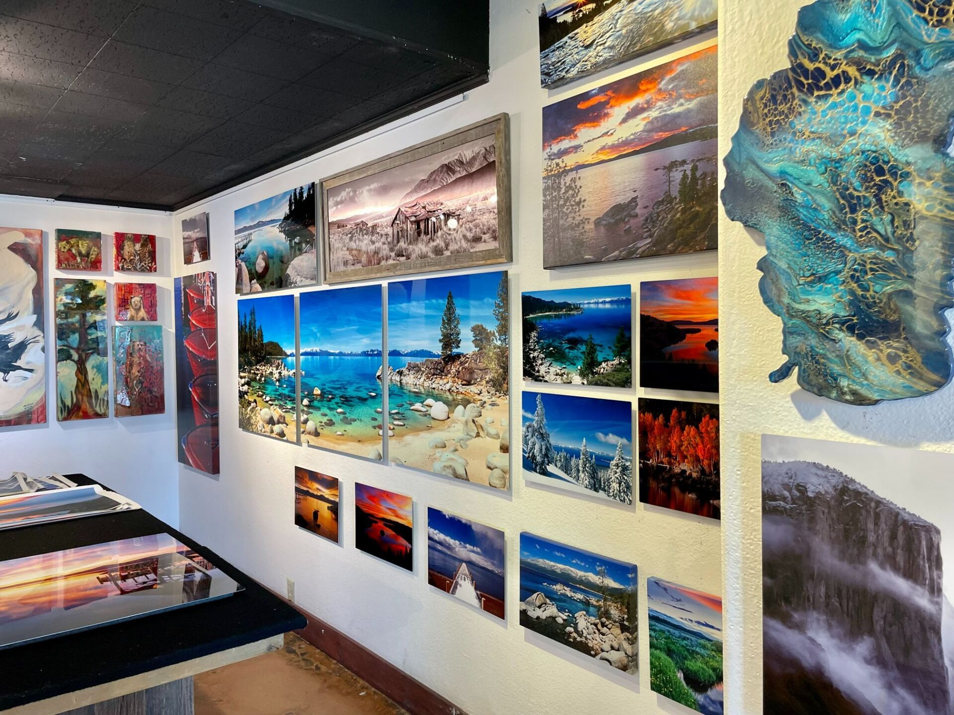 Wall gallery of colorful landscape and seascape paintings in a bright art exhibition room