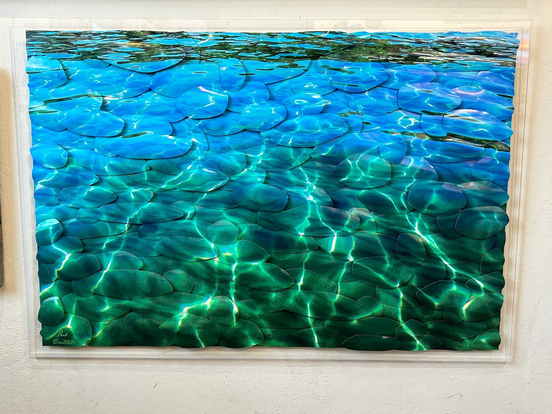 Blue-green water with sunlight ripples framed like a painting