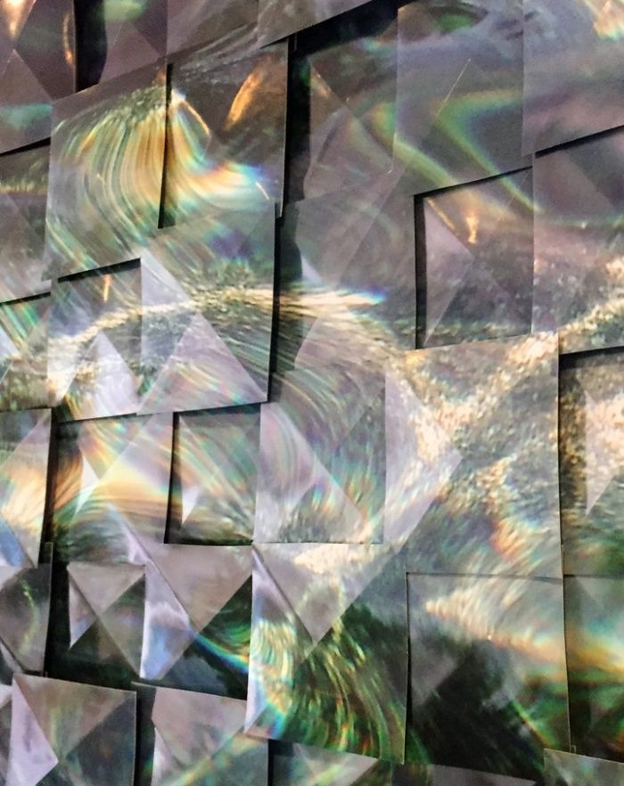 Abstract iridescent geometric panels with shimmering silver, green, and purple reflections