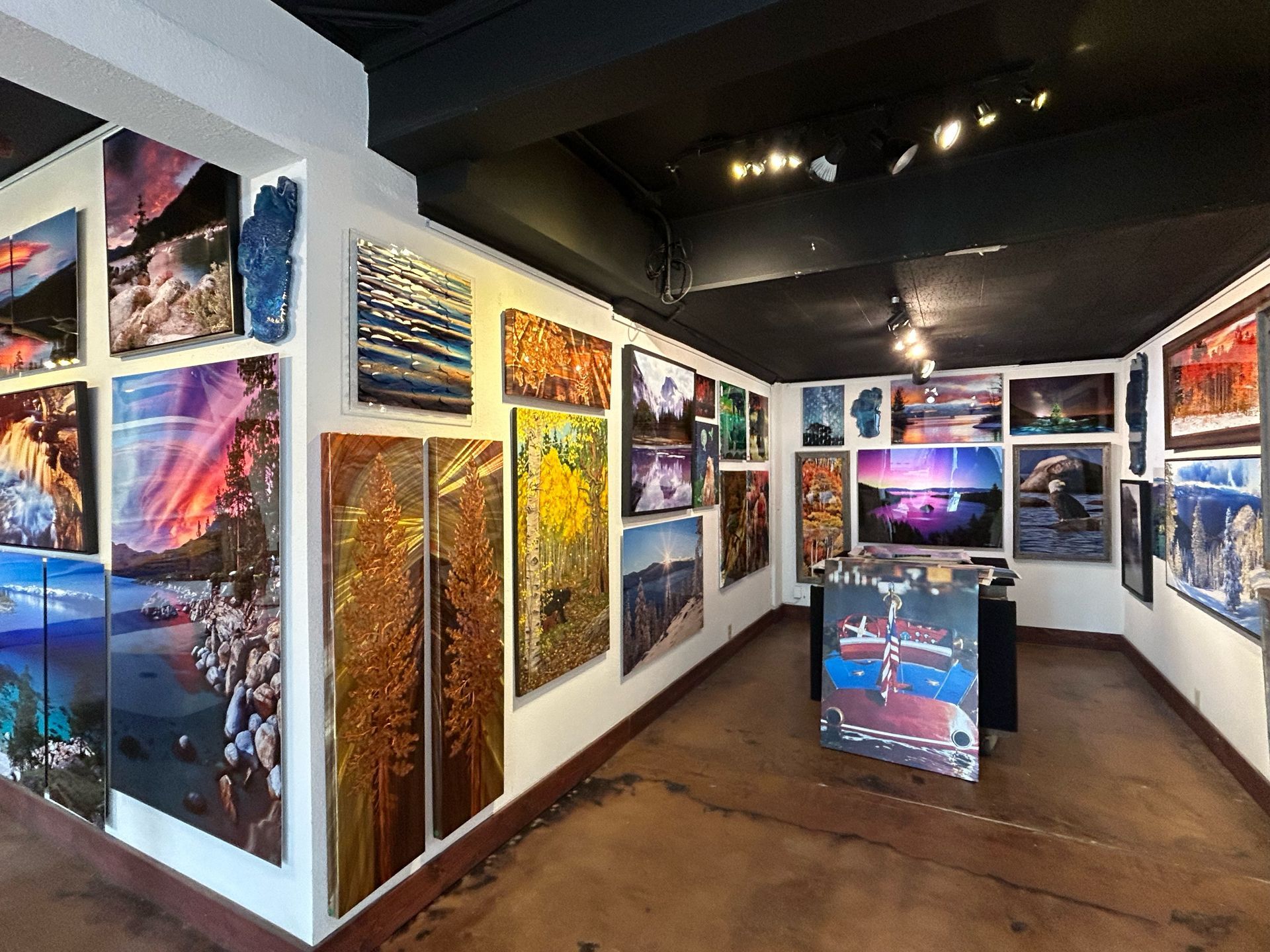 Art gallery hallway filled with colorful framed landscape and abstract photographs on white walls
