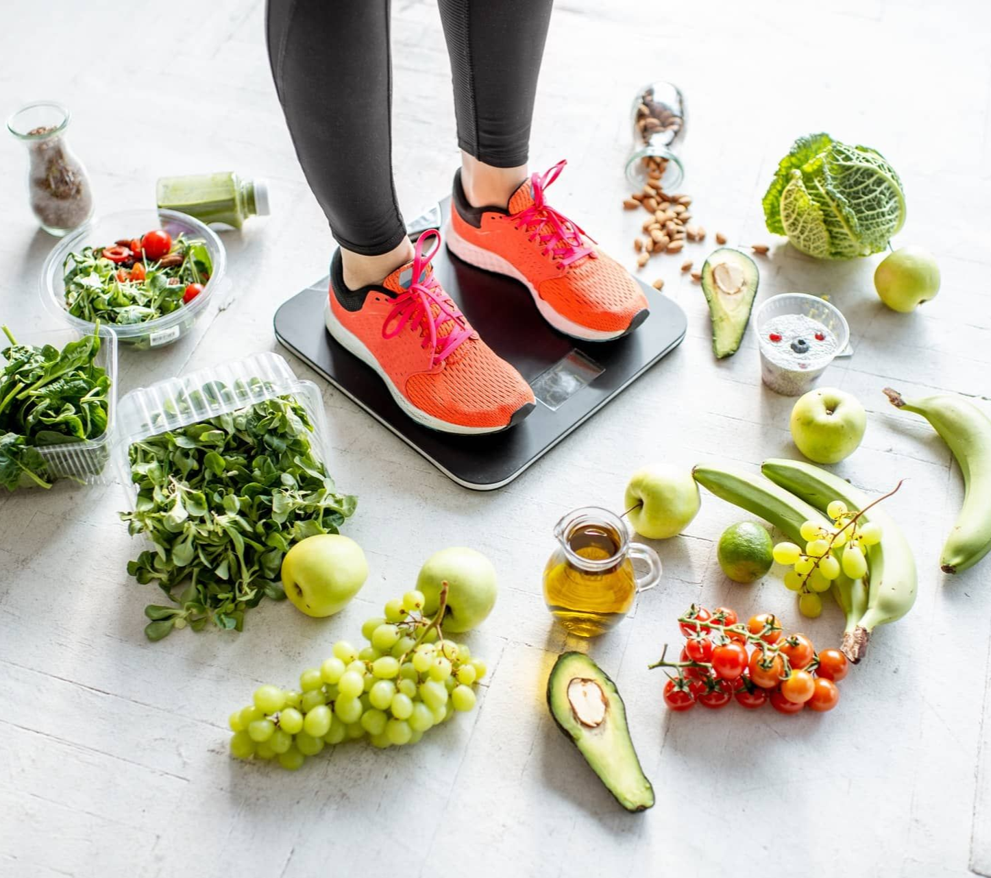 Woman standing on scale surrounded by healthy food