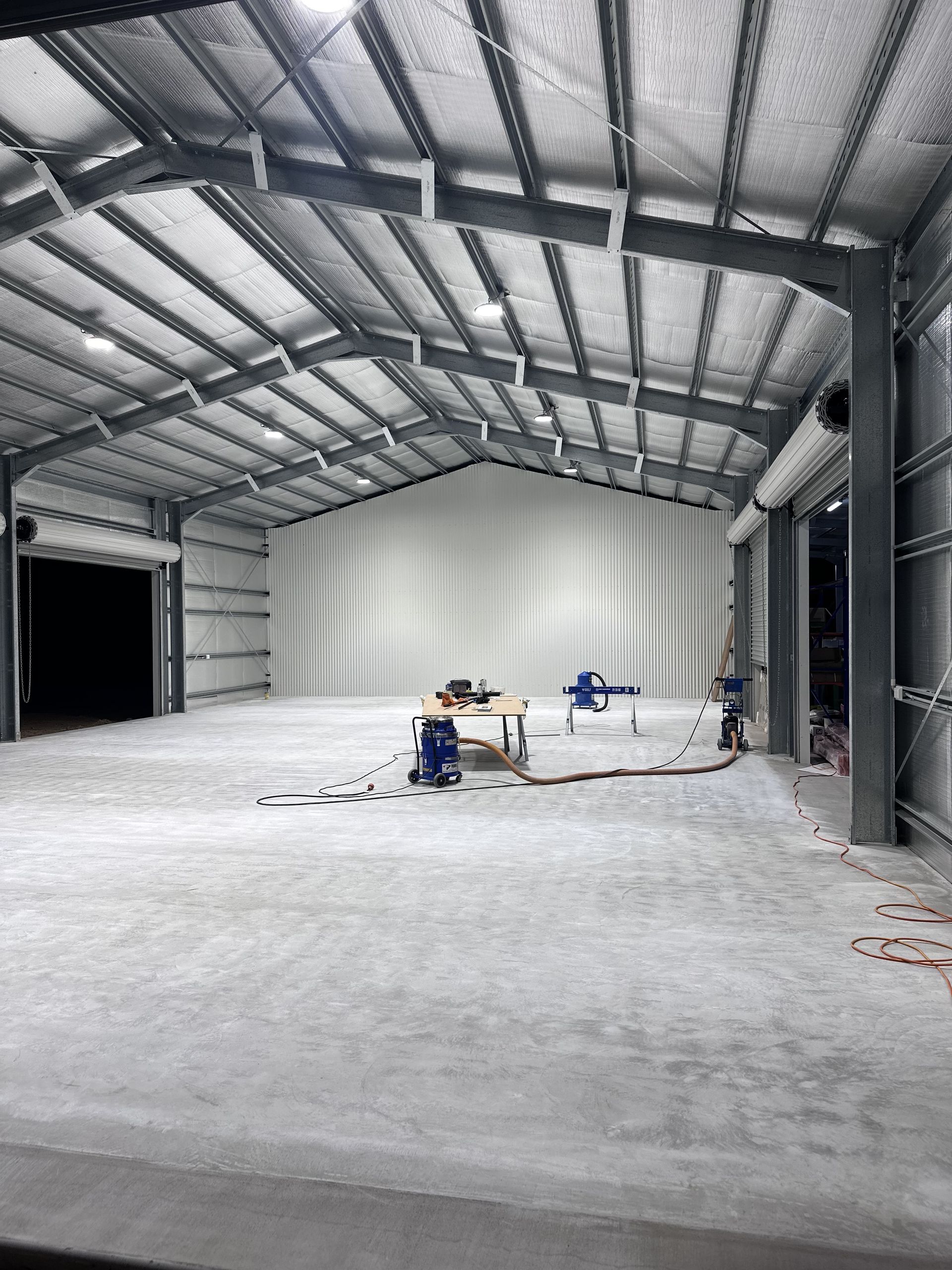 Large Empty Warehouse Interior With a Metal Roof, Concrete Floor — CQ Pro-Lec in Pacific Heights, QLD