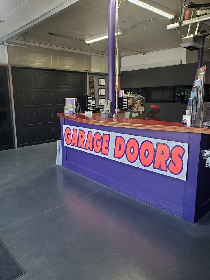 Garage doors service counter with purple trim and large red-and-white sign in a garage showroom
