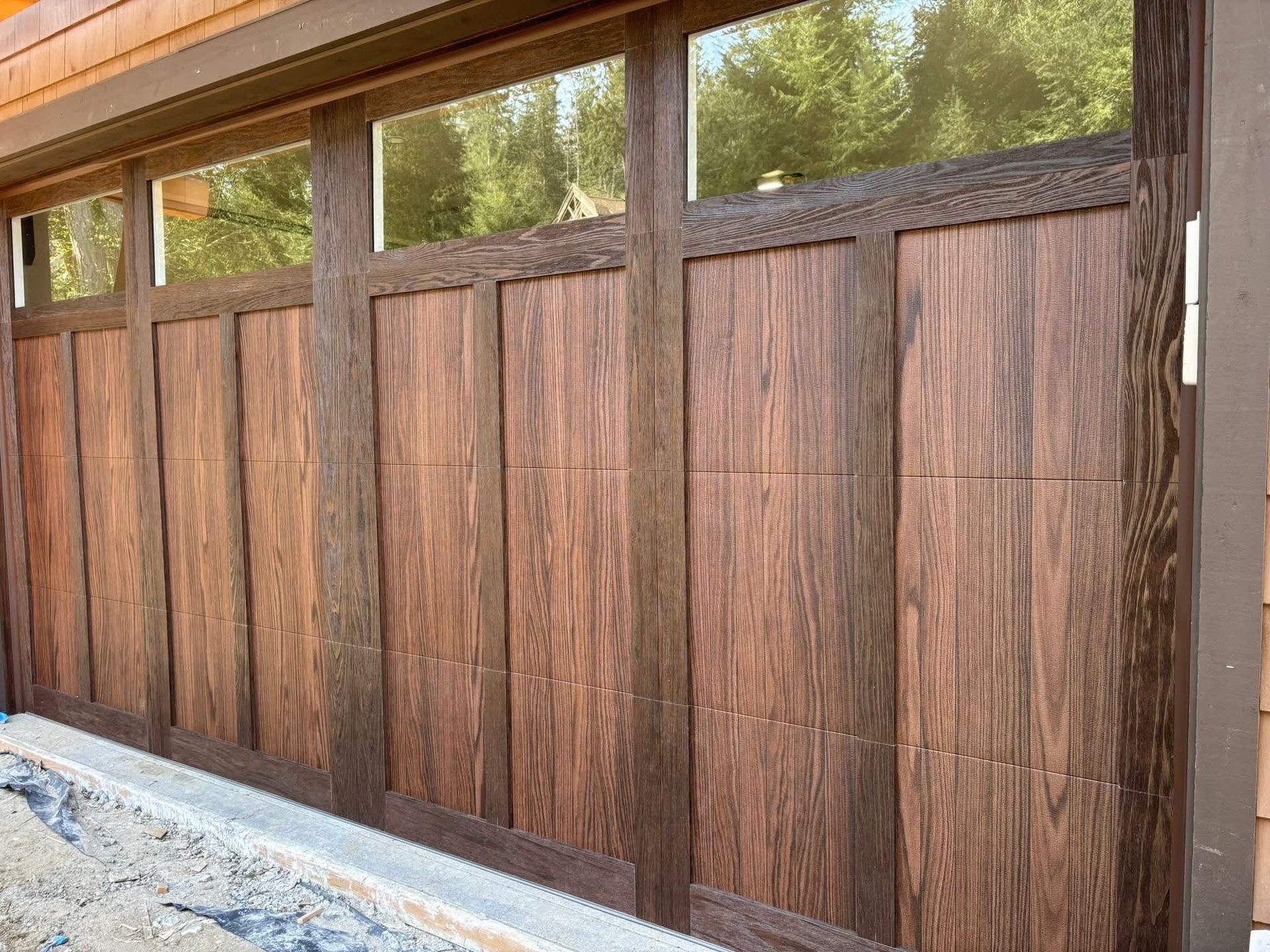 Wooden outdoor fence panels with horizontal and vertical wood grain, under a windowed overhang.