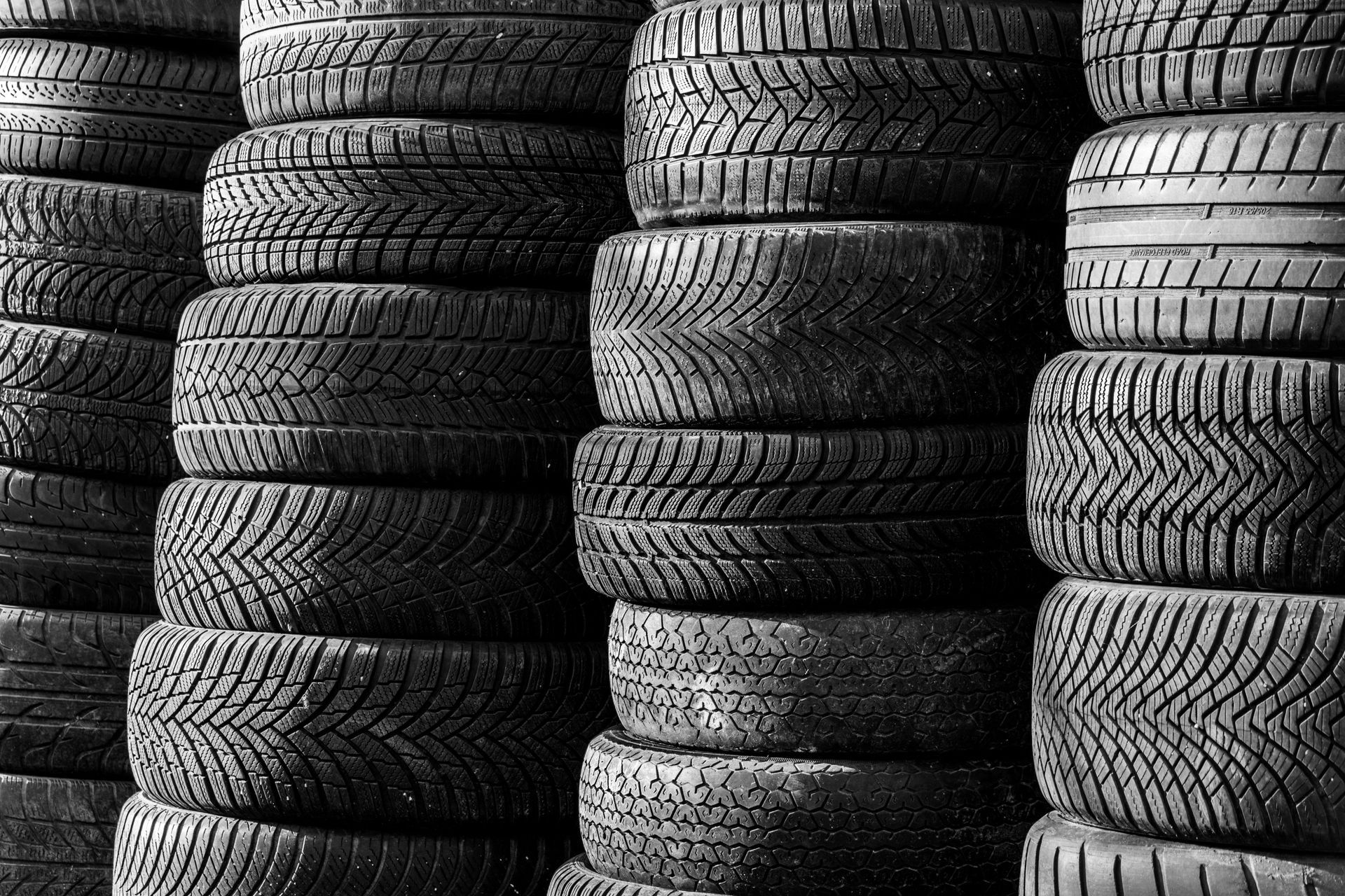 Stacked black tires arranged in vertical rows, filling the frame