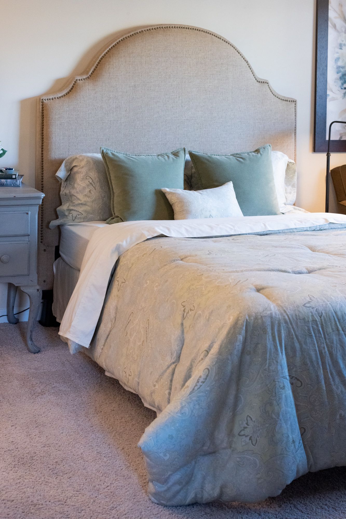 A bed with a headboard and pillows in a bedroom