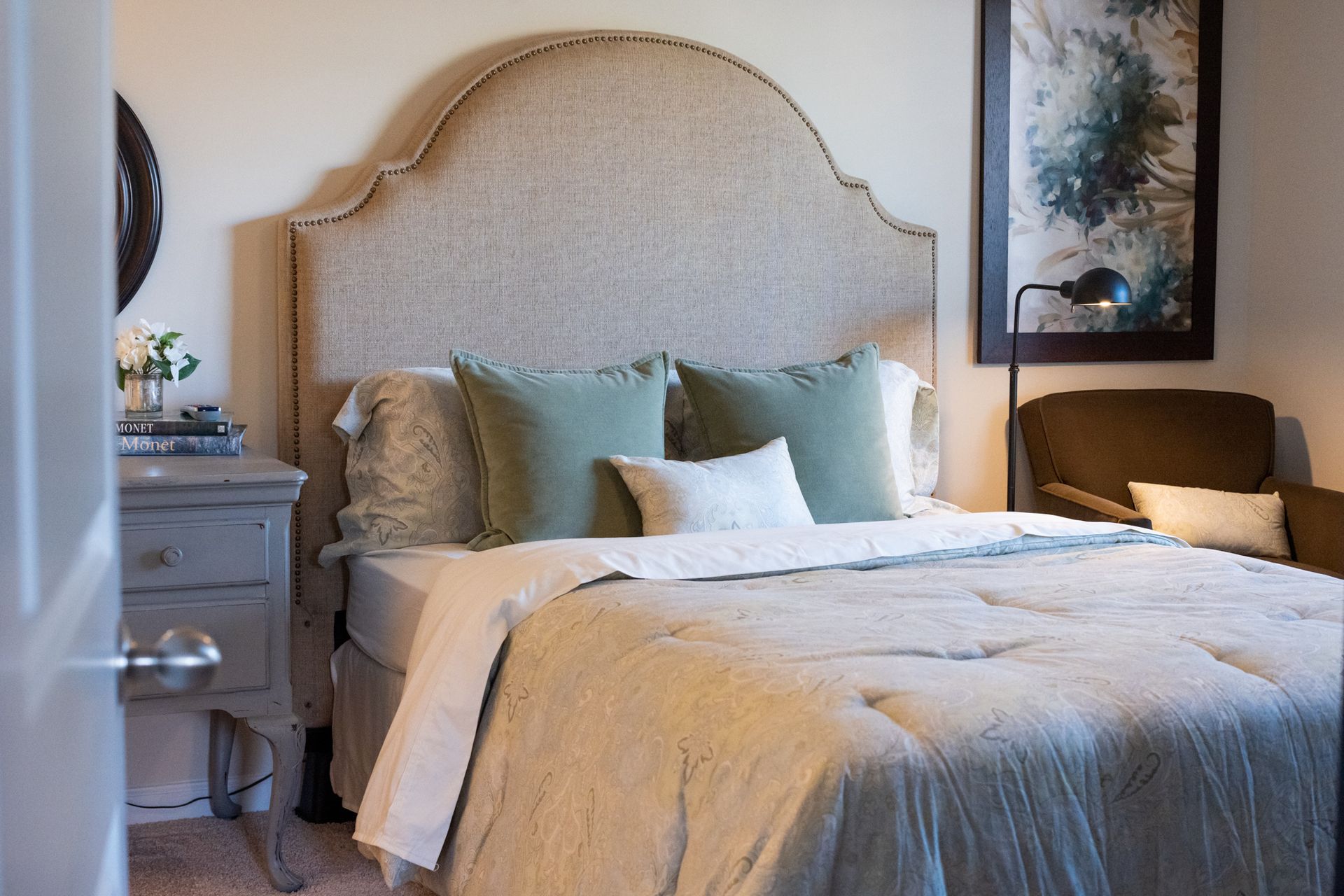 A bedroom with a bed , nightstand and chair