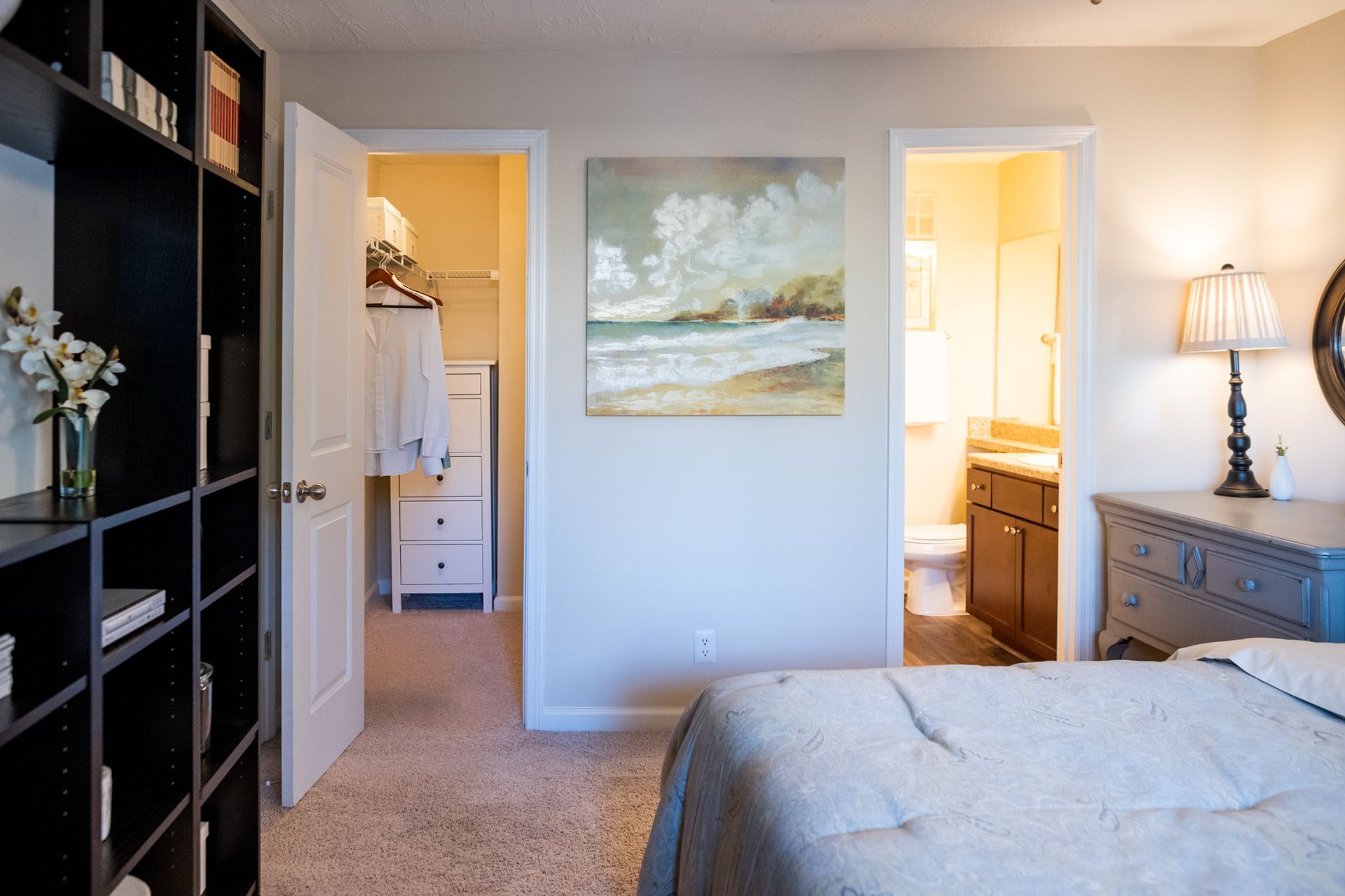 There is a painting on the wall above the bed in the bedroom.