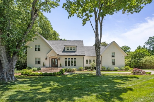 A large white house with a tree in front of it