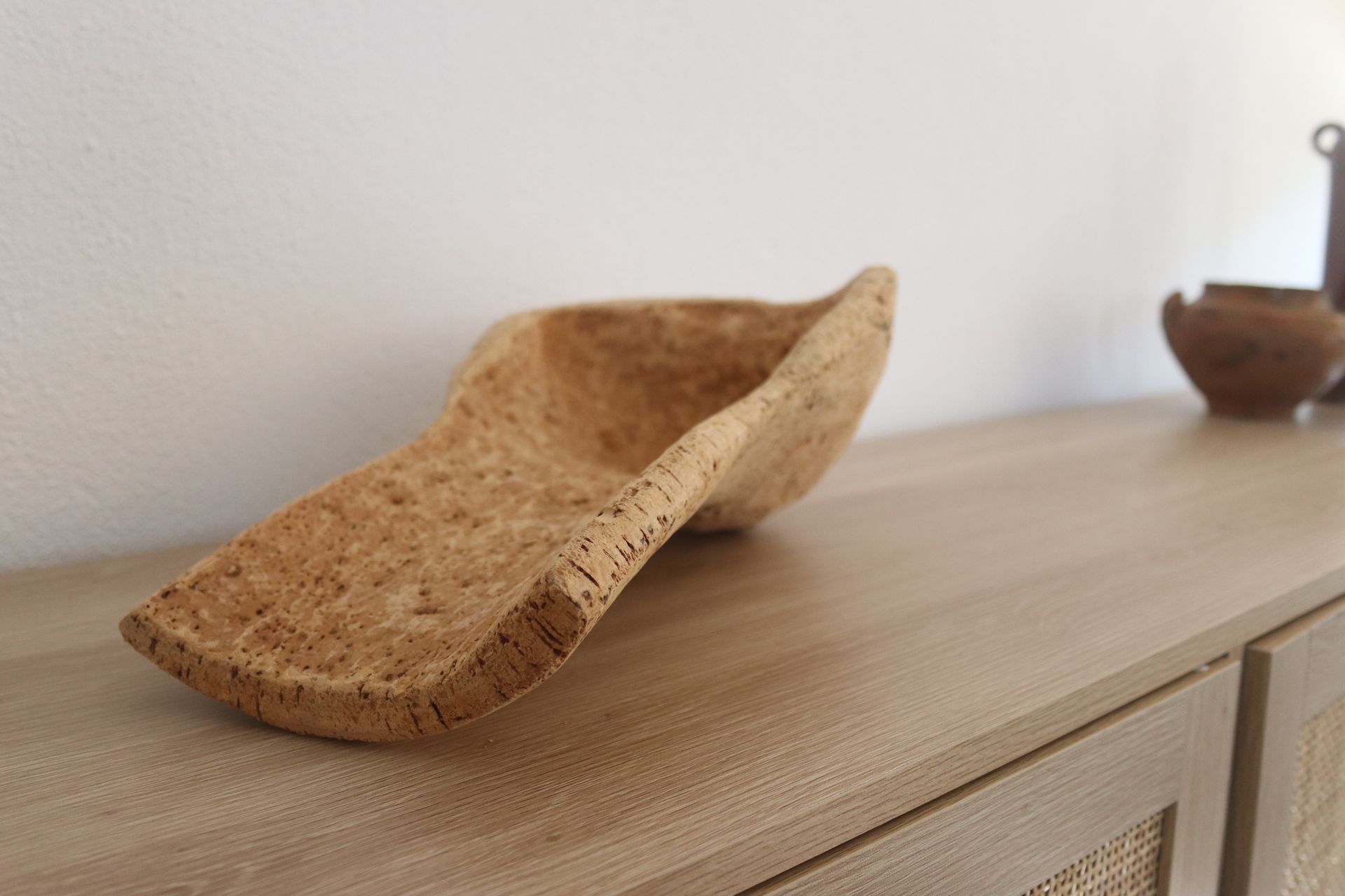 Uma peça de artesanato, esculpida a partir da casca do sobreiro, sobre um aparador numa sala de estar.