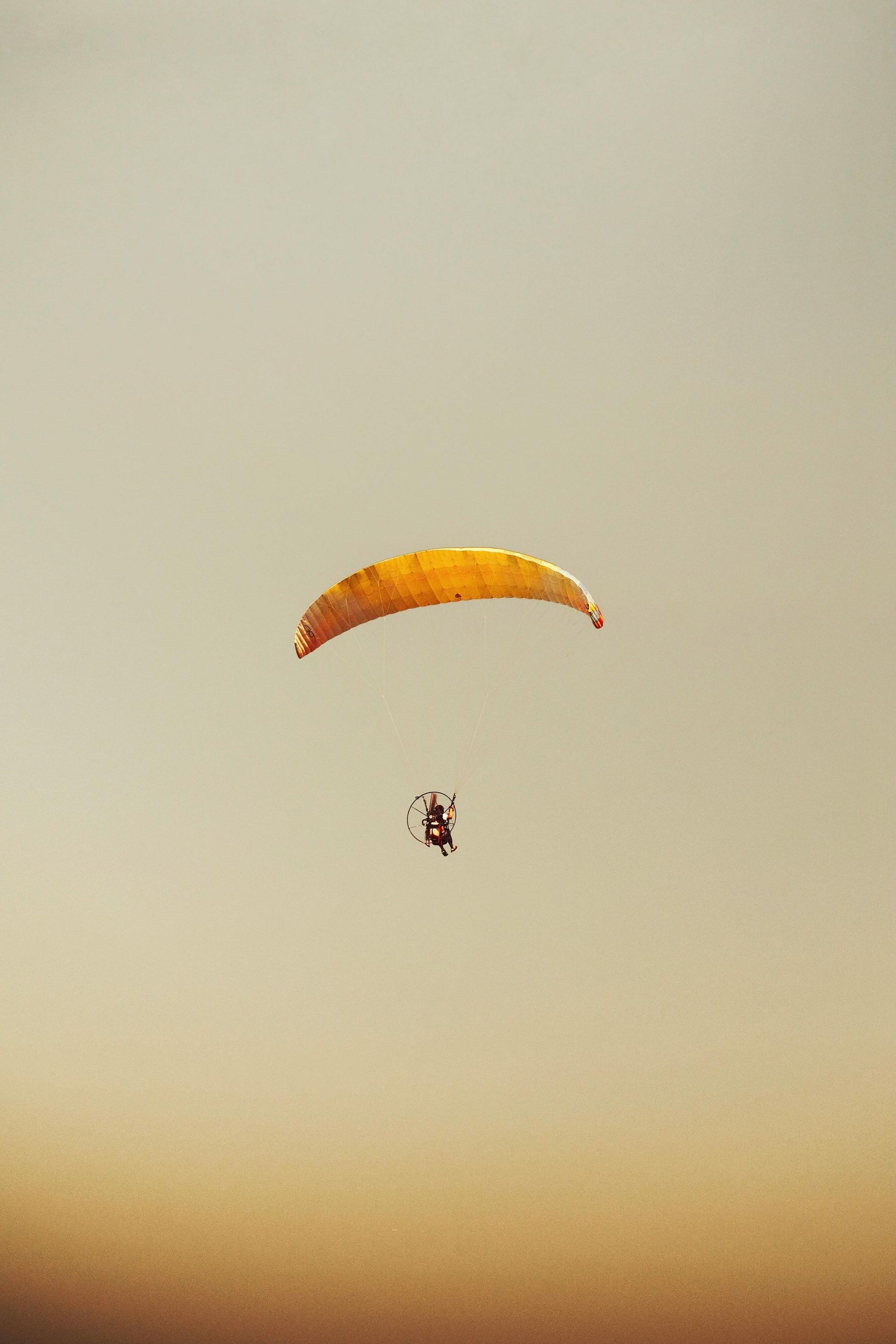 Uma pessoa está voando de paramotor no céu.