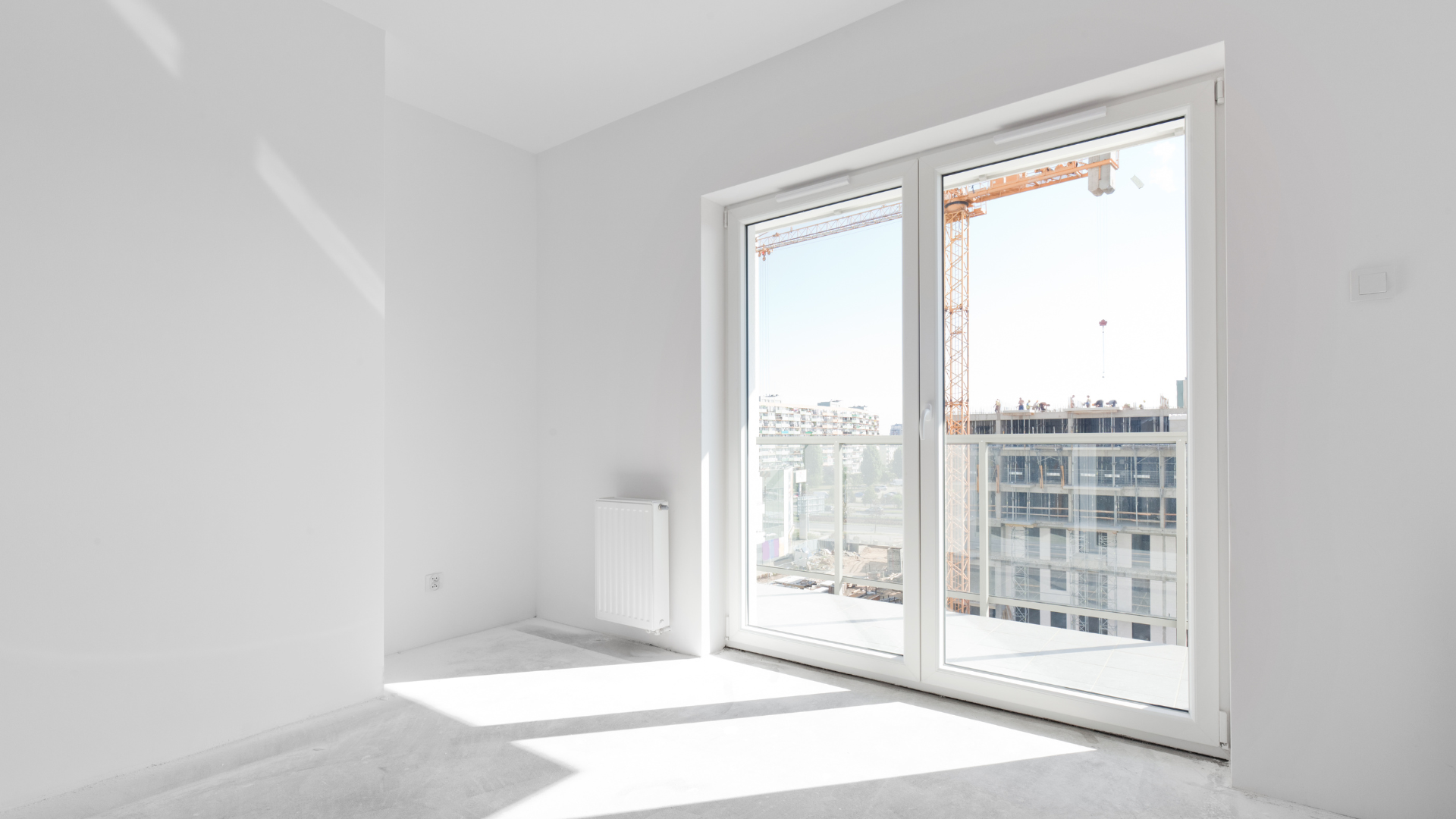 Ein leerer Raum mit einem großen Fenster und einem Balkon.