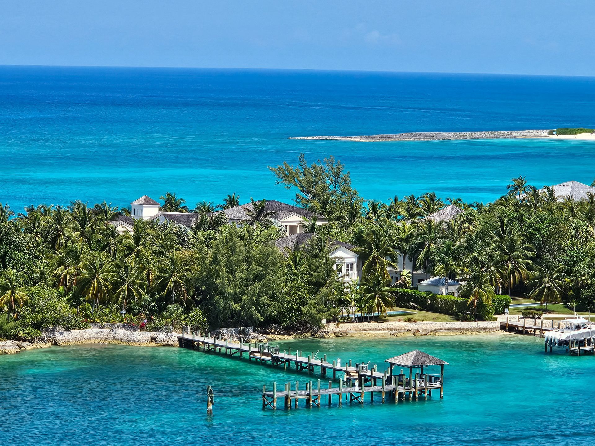 Tropical lagoon with turquoise water, palm trees, and small docks under a bright blue sky