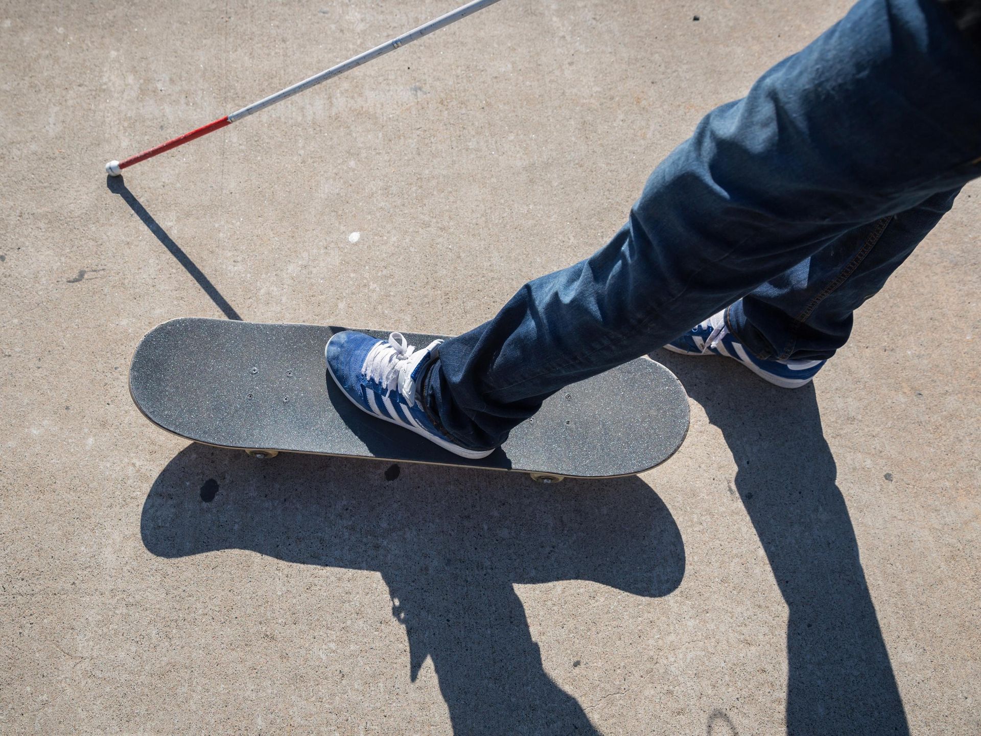 A skateboarder prepares to push on concrete.