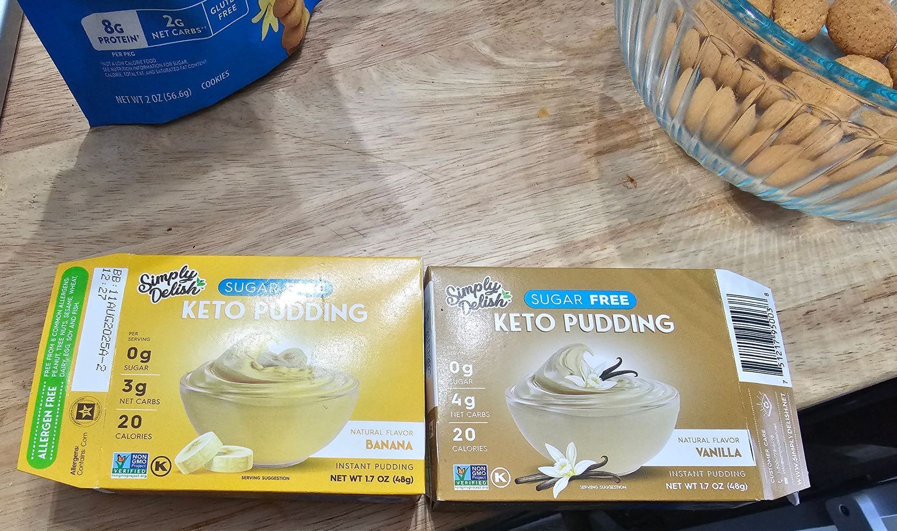 Two boxes of Keto pudding, one yellow, one brown, next to cookies.