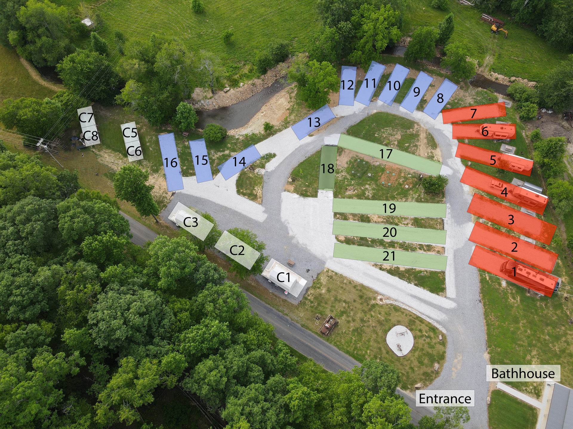 Aerial view of a campground with RV sites labeled in different colors. Sites are arranged around curved roadways.