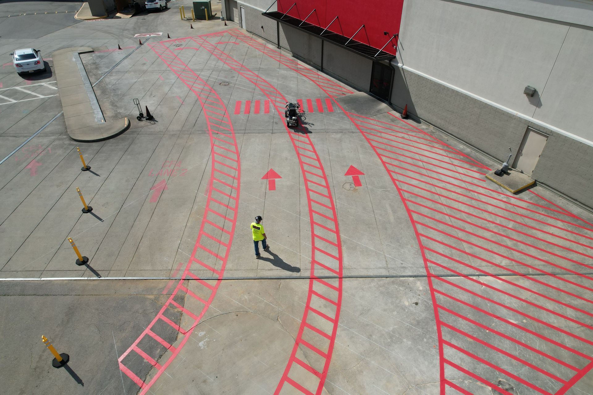 Aerial view of a construction site with red lane markings and two workers in high-visibility vests.