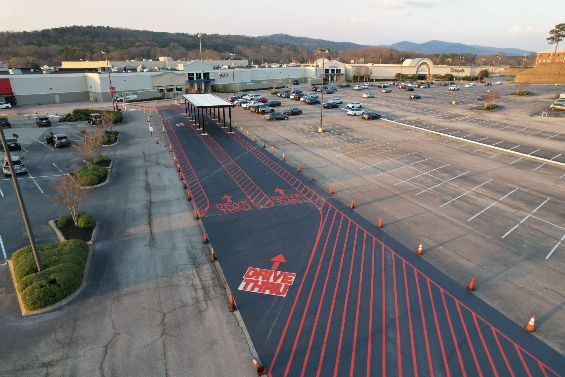 Empty parking lot with a red-striped pedestrian lane leading to a store entrance at dusk