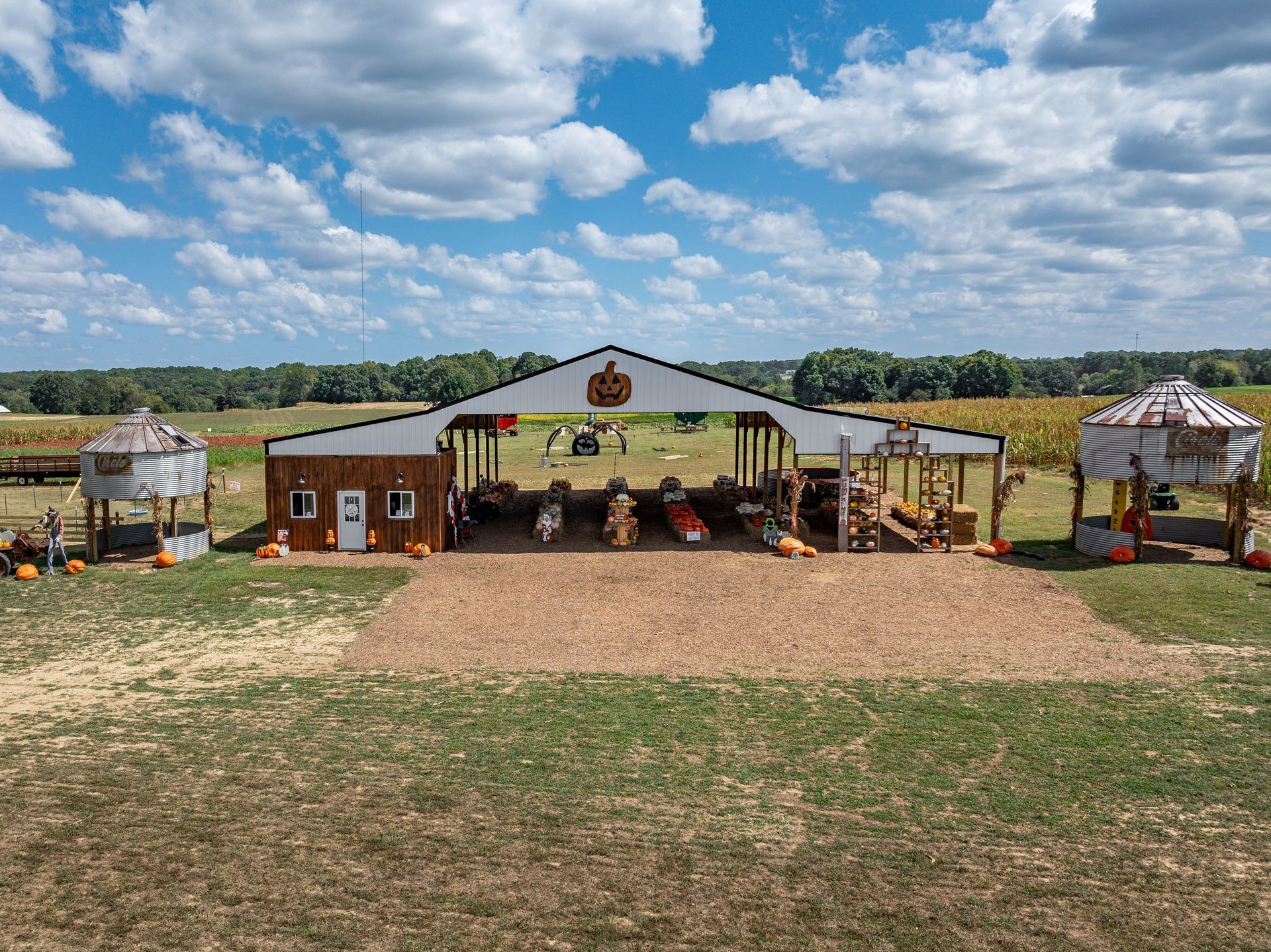A pumpkin patch with a large building in the middle of a field.