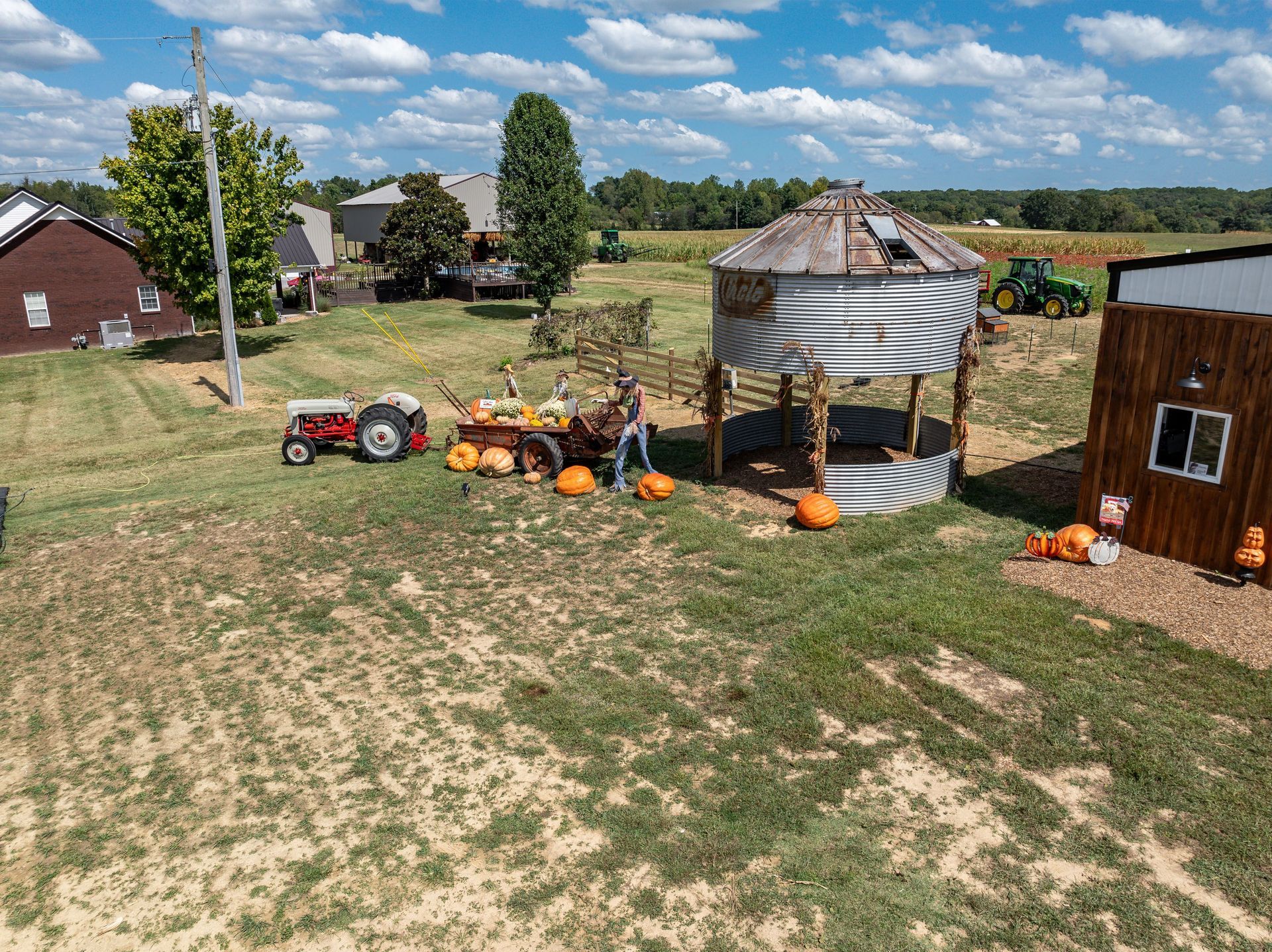 An aerial view of a pumpkin patch with pumpkins and tractors.