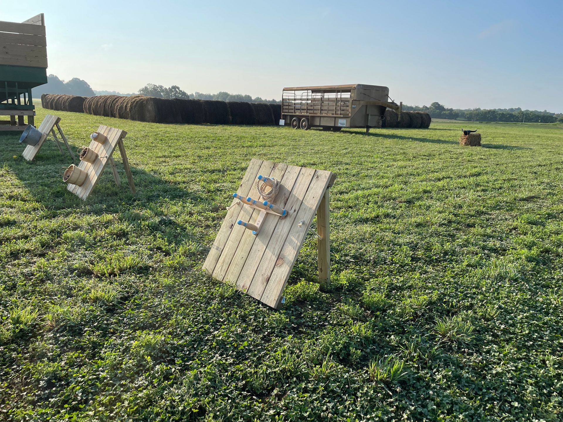 A field of grass with a wooden table in the middle of it.