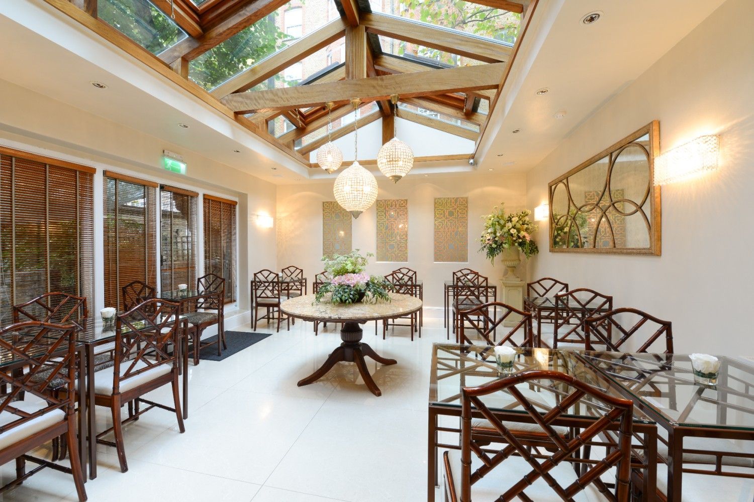 Bright interior space with skylight, round table, and decorative chairs.