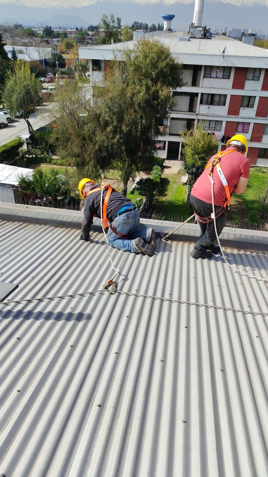 Equipo instalando y reparando techumbre residencial con l&aacute;mina met&aacute;lica nueva.