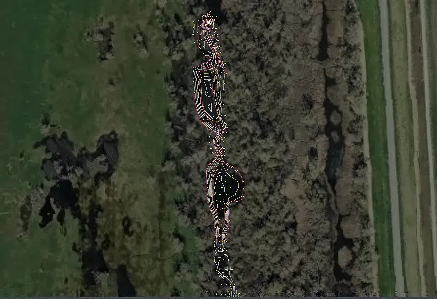 Aerial view of a winding waterway, with marshy vegetation on either side and a lighter-colored path overlaid.