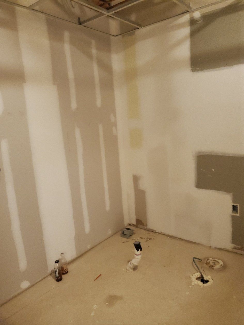 A room with drywall on the walls and a hole in the floor.