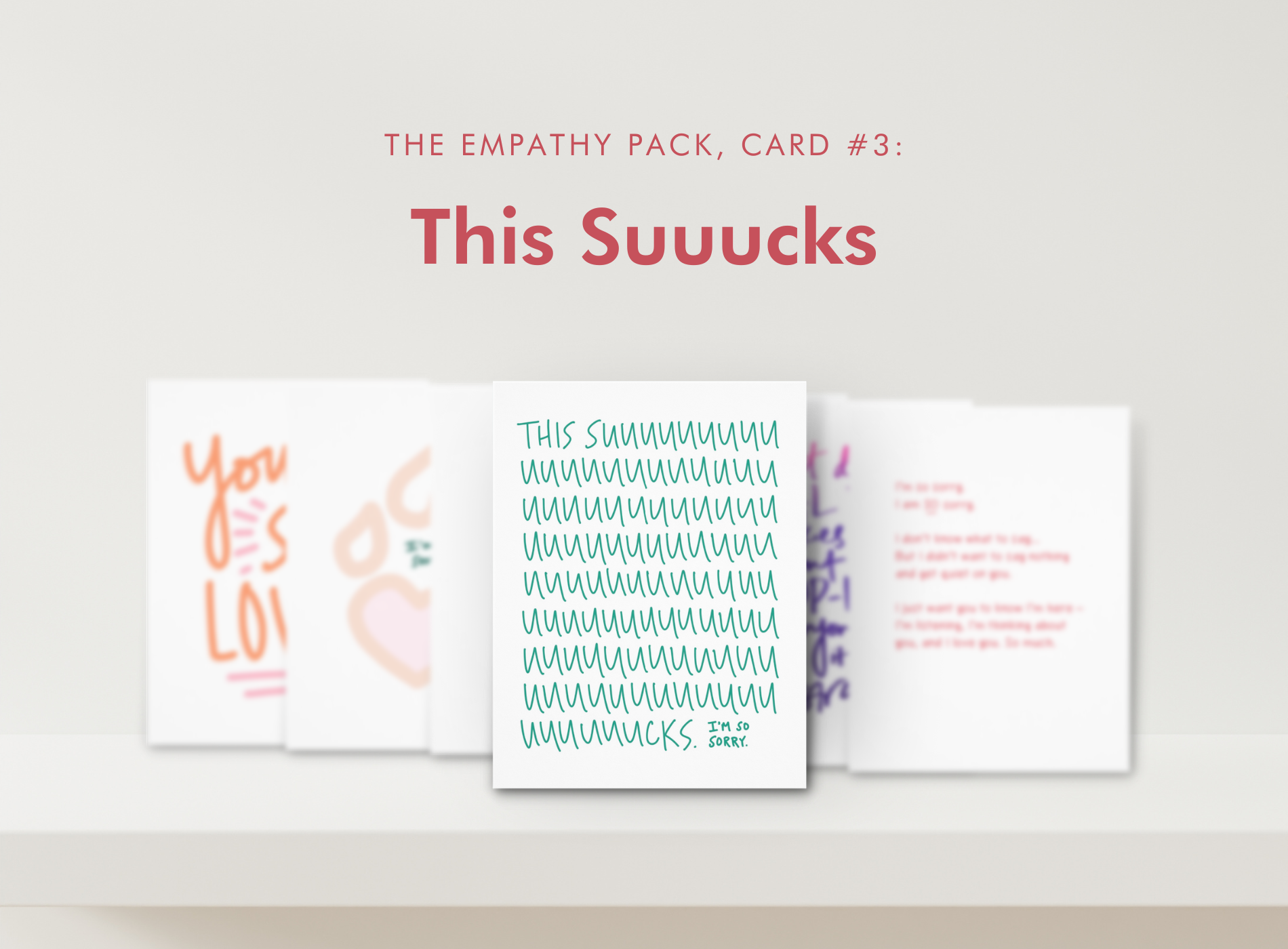 Four self-care cards on a white shelf under the title “This Suucks” in red text.