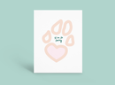 Pastel peach paw print with small green Japanese text on a white card against a mint background