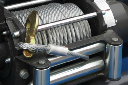 Close-up of a winch drum with coiled steel cable and a hook attached to the line