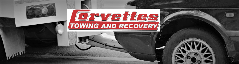 Tow truck with &ldquo;Corvettes Towing and Recovery&rdquo; logo, showing a car wheel and tow equipment